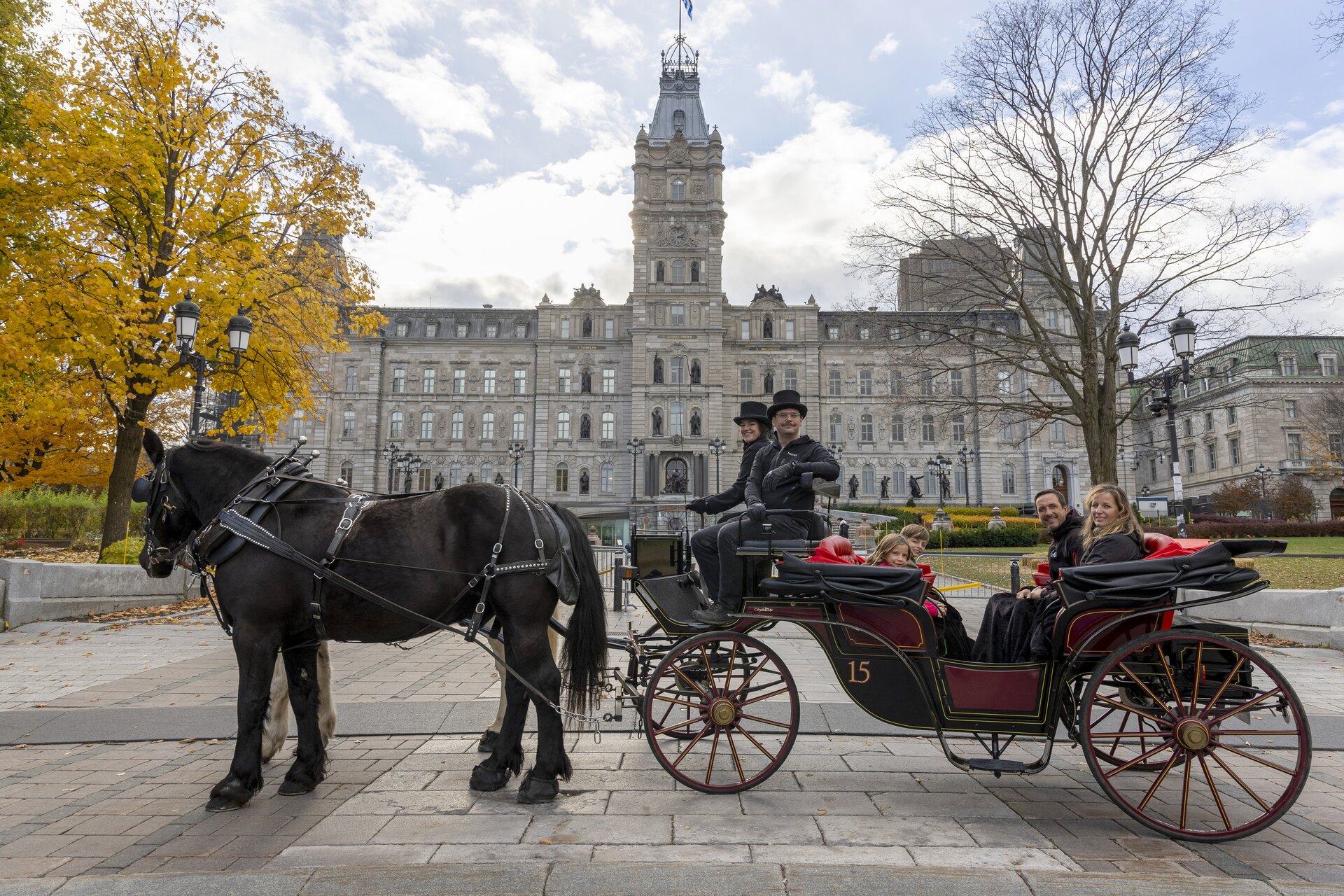 A horse, carriage, crew and passengers in front of Québec’s Parliament building.